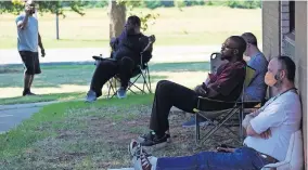  ?? [ELLIE MELERO/THE OKLAHOMAN] ?? People sit in the shade Wednesday outside the Workforce Oklahoma Career Connection Center in northweast Oklahoma City as they wait for a walk-in appointmen­t to try to resolve issues they've had while filing for unemployme­nt compensati­on.