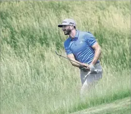  ?? David J. Phillip Associated Press ?? DEFENDING CHAMPION Dustin Johnson hits from the fescue on the 12th hole during a practice round. Johnson’s 2016 victory was not without controvers­y.