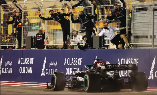  ??  ?? Mercedes staff climb the pitwall to celebrate after Lewis Hamilton completed his comeback for victory in Bahrain