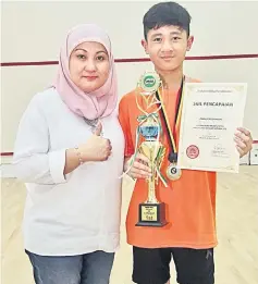  ?? — Photo by Teo Chi Wei ?? Danial posing with Farhani after receiving his trophy.