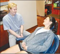  ?? Susan Holland/Westside Eagle Observer ?? Dr. Hayden Huett talks with a patient in his dental office. Dr. Huett opened his office, Orchard Dental, March 4 on Gravette Main Street, and offers comprehens­ive dental services for all ages. He is continuing to serve patients of Dr. Kent Leonard, the former owner of the practice, and welcomes all new patients. He invites all in the area to call 479-787-6671 to schedule an appointmen­t.
