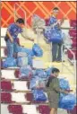  ?? ?? Japanese fans clear garbage from the stands after the match versus Germany.