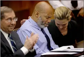  ?? CHRISTIAN GOODEN — ST. LOUIS POST- DISPATCH POOL PHOTO ?? Lamar Johnson, center and his attorneys react on Tuesday after St. Louis Circuit Judge David Mason vacated his murder conviction during a hearing in St. Louis.