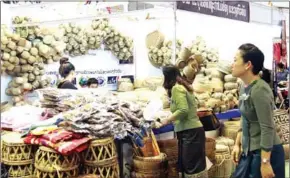  ?? VIENTIANE TIMES ?? Shoppers examine woven products at a stall during the annual Lao Handicraft­s Festival in Vientiane.