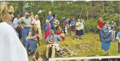  ?? PHOTO BY CHRIS GREEN; VINTAGE PHOTO COURTESY OF LORI RITENOUR PEREGORY ?? Amissville Full Gospel Church congregant­s gather on the banks of the North Fork of the Thornton River last weekend, including Lori Ritenour Peregory (kneeling with camera in red) and her son, Bryce (standing beside her). Lori provided the vintage...