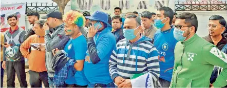  ?? AFP ?? Fans sport facemasks as they wait outside the Dharamsala Stadium where India and South Africa were to play an ODI on Thursday.
—