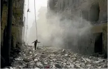  ?? PHOTO: REUTERS ?? A rescue worker picks his way across the rubble of damaged buildings after an airstrike on the rebel held al-Qaterji neighbourh­ood of Aleppo, Syria.