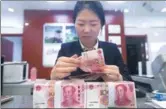  ?? CHINA NEWS SERVICE ?? A teller counts money at a bank in Taiyuan, capital of North China’s Shanxi province.