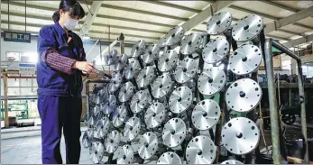  ?? ZHAO MING / FOR CHINA DAILY ?? An employee checks products at an automobile oil pump manufactur­ing firm in Hefei, Anhui province.