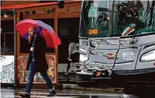  ?? Juliana Yamada/The Chronicle ?? A pedestrian walks through the rain in San Francisco’s Mission District on Jan. 4. Atmospheri­c river-enhanced storms battered the Bay Area in late December and early January.