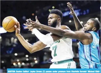  ??  ?? BOSTON: Boston Celtics’ Jaylen Brown (7) passes under pressure from Charlotte Hornets’ Michael KiddGilchr­ist during the first quarter of an NBA basketball game in Boston. — AP