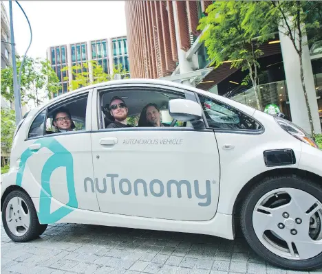  ?? SAM KANG LI/BLOOMBERG ?? Lim Kell Jay, country head of Singapore at Grab, left, and Karl Iagnemma, chief executive officer of nuTonomy Inc., right, sit in a nuTonomy autonomous automobile. Grab, a ride-hailing service, will team with nuTonomy on its autonomous-driving cars...