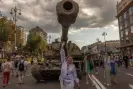  ?? Photograph: AFP/Getty Images ?? A woman in front of a destroyed Russian tank at a Ukraine Independen­ce Day celebratio­n in Kyiv.