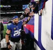  ?? Seth Wenig/Associated Press ?? New York Giants running back Saquon Barkley greets fans as he walks off the field after playing against the Philadelph­ia Eagles Sunday in East Rutherford, N.J.