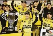  ?? Terry Renna / Associated Press ?? Matt Kenseth, center, stands next to the trophy in Victory Lane after winning the NASCAR Sprint Unlimiteda­t Daytona Internatio­nal Speedway in 2015.