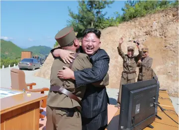  ?? (Reuters) ?? NORTH KOREAN leader Kim Jong Un reacts with scientists and technician­s of the DPRK Academy of Defense Science after the test-launch of the interconti­nental ballistic missile Hwasong-14 in this undated photo released by Pyongyang yesterday.