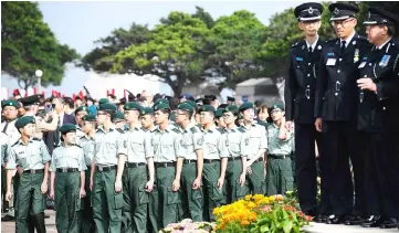  ??  ?? Members of the Hong Kong Army Cadets Associatio­n (HKACA) (left), set up in 2015, pose for a group photo after taking part in an annual flag raising ceremony in Hong Kong. — AFP photo