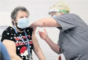  ??  ?? Hospital Volunteer Norma Roe, 80, receiving the first COVID-19 vaccinatio­n to be administer­ed from East Lancashire Hospitals NHS Trust