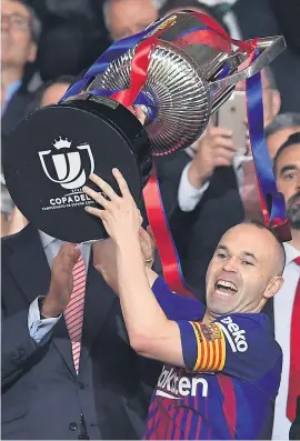  ?? Picture: AFP ?? GOING OUT IN STYLE. Barcelona captain Andres Iniesta lifts the Copa del Rey trophy after beating Sevilla in the final at the Wanda Metropolit­ano in Madrid on Saturday.