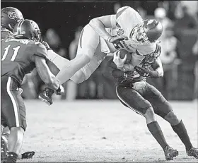  ?? Arkansas Democrat-Gazette/BENJAMIN KRAIN ?? Arkansas backup quarterbac­k Cole Kelley leaps over South Carolina defenders during the fourth quarter of their game Saturday. Kelley threw for 140 yards and a touchdown in the Razorbacks’ 48-22 loss.