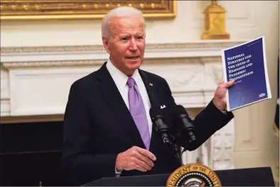  ?? Alex Brandon / Associated Press ?? President Joe Biden holds a booklet as he speaks about the coronaviru­s in the State Dinning Room of the White House in Washington, D. C., on Thursday.
