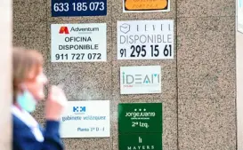  ??  ?? Una mujer junto a carteles de pisos en alquiler en Madrid