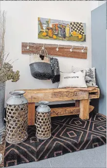  ??  ?? Rustic bench, coat hooks on barnboard and Joan Heyerichs’ scenic painting of a gameboard, fruit and refreshmen­ts.