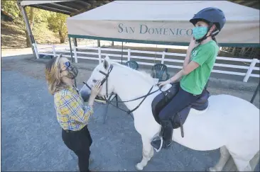  ?? SHERRY LAVARS — MARIN INDEPENDEN­T JOURNAL ?? Assistant trainer Justine Moodyworks with Sarah Haskell, 13, during a riding lesson at Patrick Seaton Stables at San Domenico School in San Anselmo on Tuesday.