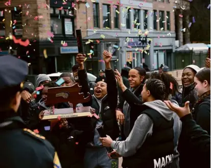  ?? JONATHAN WIGGS/GLOBE STAFF ?? LET’S CELEBRATE: The City of Boston honored the four BPS winter state champions with a parade on Saturday, starting from the Park Street T station at Boston Common. The Cathedral girls’ basketball players got things going as they set off confetti poppers.