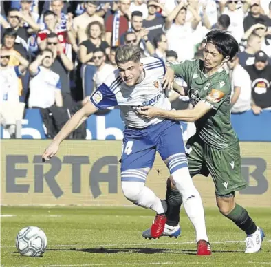  ?? JAVIER BELVER ?? Guti pugna por un balón con el deportivis­ta Gaku durante el partido jugado en La Romareda.