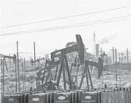  ??  ?? Oil derricks and other infrastruc­ture pump oil and gases as well as dominate the landscape in Kern County, Calif., Feb. 20, 2020.