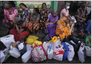  ?? (AP/Eranga Jayawarden­a) ?? Women wait near an empty fuel station hoping to buy kerosene oil for cooking in Colombo, Sri Lanka, in May. Sri Lankans for months have been forced to stand in long lines to buy scarce essentials, with many returning home empty-handed in a drawn-out failure of the island nation’s economy.