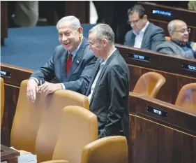  ?? (Yonatan Sindel/Flash90) ?? PRIME MINISTER Benjamin Netanyahu and Justice Minister Yariv Levin enjoy a light moment in the Knesset plenum.