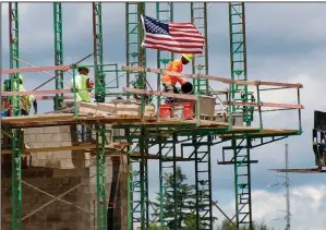  ?? (AP) ?? Workers lay concrete blocks at a residentia­l and commercial site going up in June in Cranberry Township, Pa. The government reported Friday that the number of hours worked in the second quarter fell 43% as the pandemic dragged on.