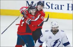  ?? The Associated Press ?? Washington Capitals forwards T.J. Oshie, left, and Nicklas Backstrom celebrate a goal by Oshie as Alex Killorn (17) of the Tampa Bay Lightning looks on during Game 6 in their NHL Eastern Conference final on Monday in Washington.