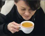  ?? (AP/Kin Cheung) ?? A customer drinks her Hong Kong-style milk tea Nov. 18 in the HOKO Cafe in London.