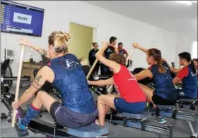  ?? MICHILEA PATTERSON — DIGITAL FIRST MEDIA ?? Women of the Philadelph­ia Dragon Boat Associatio­n paddle on indoor rowers inside the new erg room of the Pottstown Athletic Club. The rowers are connected to a monitor that tracks and compares the speed everyone paddles.