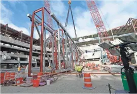  ?? MIKE DE SISTI / MILWAUKEE JOURNAL SENTINEL ?? The truss was secured upright in steel beams before being lifted into place. Wednesday morning, the second half of the main truss will be raised, a 150-foot-long section.