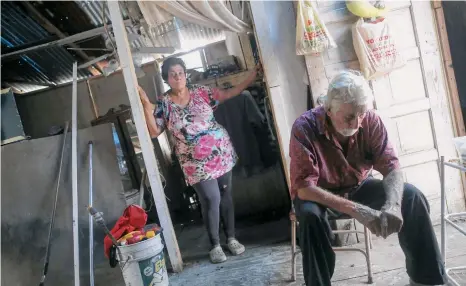  ?? /GETTY IMAGES ?? Rosa y Errol esperan pacientes por la ayuda en su hogar de San Isidro, afectado por el paso de María.