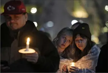  ?? Charlie Riedel/Associated Press ?? People attend a candleligh­t vigil for victims of a shooting at a Kansas City Chiefs Super Bowl victory rally Thursday, in Kansas City, Mo. Two teenagers in custody in connection with the deadly shooting during the rally that left one woman dead and more than 20 others injured were charged, according to Missouri court officials.