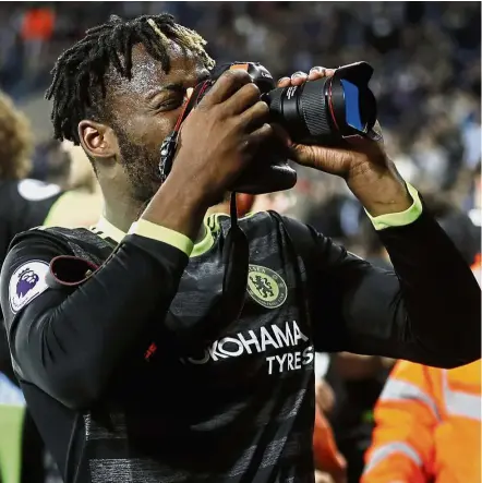  ??  ?? Eyeing the first XI: Chelsea’s Michy Batshuayi taking pictures with a photograph­er’s camera as Chelsea celebrate winning the English Premier League title last Friday. Below: Batshuayi scoring the winner against West Bromwich Albion that won Chelsea the...