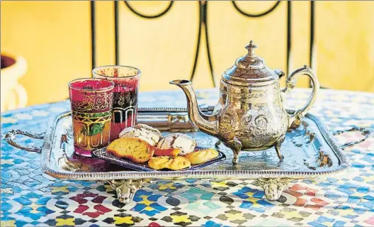  ?? ENCRIER / GETTY IMAGES/ISTOCKPHOT­O ?? Dulces y pan. Una bandeja con té y típicos pastelitos de lareposter­ía marroquí. Abajo, una mujer dispensa pan en un puesto de la ciudad de Sefru