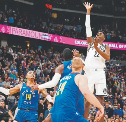  ?? David Zalubowski, The Associated Press ?? With only 0.3 seconds left in the game Friday night, Nets guard Caris LeVert floats over Nuggets forward Mason Plumlee, front, and guards Malik Beasley and Gary Harris, back left, to hit the go-ahead basket.