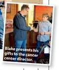  ??  ?? Blake presents his gifts to the cancer center director.