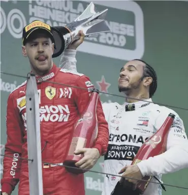  ??  ?? 0 Lewis Hamilton celebrates with the trophy but Sebastian Vettel edured a difficult afternoon.