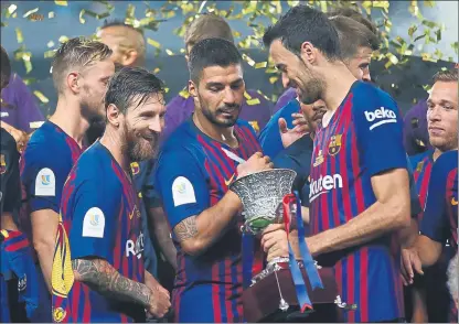  ?? FOTO: AP ?? Leo Messi, Luis Suárez y Sergio Busquets sonríen tras recibir el trofeo de la Supercopa de España