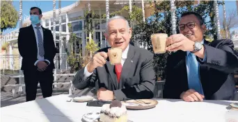  ?? OHAD ZWIGENBERG/HAARETZ ?? Israeli Prime Minister Benjamin Netanyahu, center, and Mayor Moshe Lion of Jerusalem visit a restaurant Sunday after the lifting of coronaviru­s restrictio­ns.