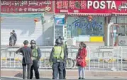  ?? AP FILE ?? Residents speak to security personnel on the streets of Hotan in China's Xinjiang region.