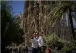  ?? Joan Mateu/AP ?? A couple pose for a picture in front of Gaudi's Sagrada Familia Basilica in Barcelona.