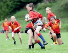  ?? ROBYN EDIE/ STUFF ?? Central girls player Zoe Middleton being tackled by a James Hargest College player at the Jonty Carran Memorial 10-a-side rugby tournament at Otautau.